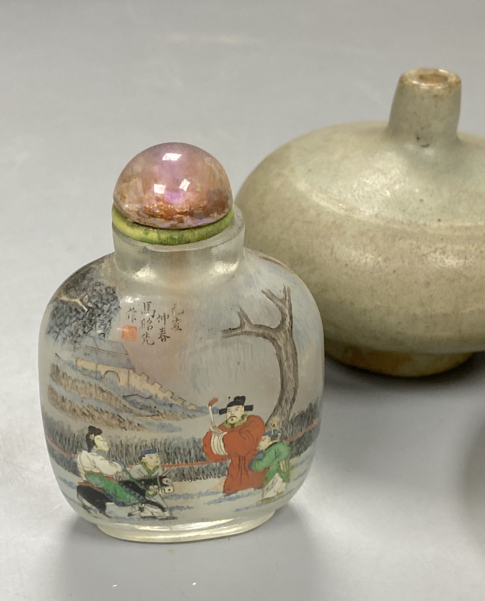 A Chinese inside painted rock crystal snuff bottle and inside painted glass snuff bottle and a small Chinese celadon jarlet, tallest 8c